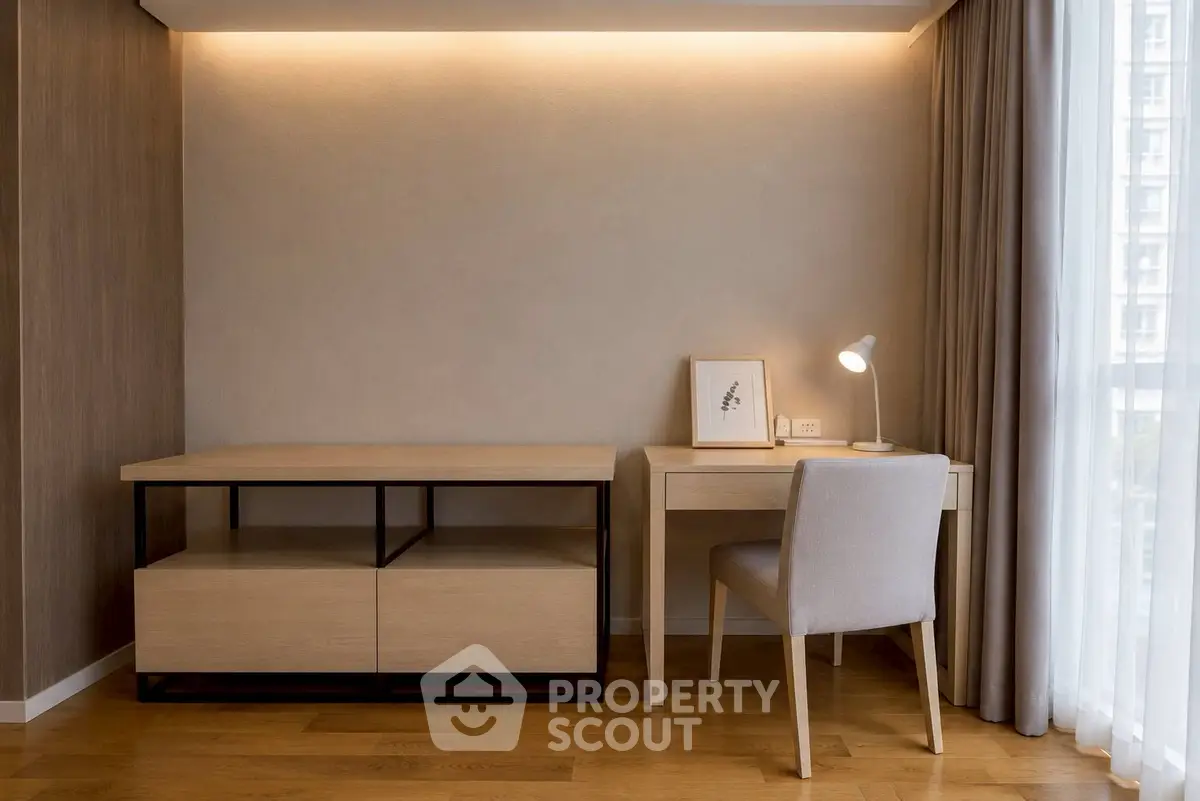 Modern study room with elegant desk and chair, featuring soft lighting and wooden flooring.