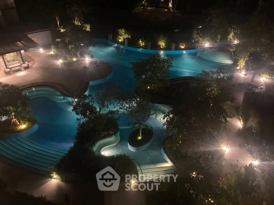Luxurious night view of illuminated outdoor swimming pool with lush greenery