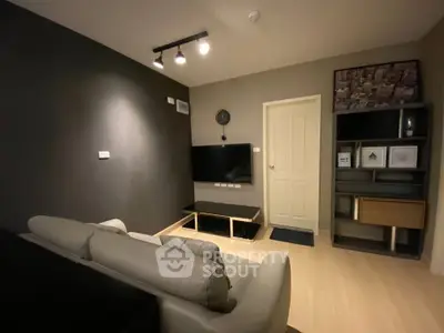 Modern living room with sleek furniture and wall-mounted TV in stylish apartment.