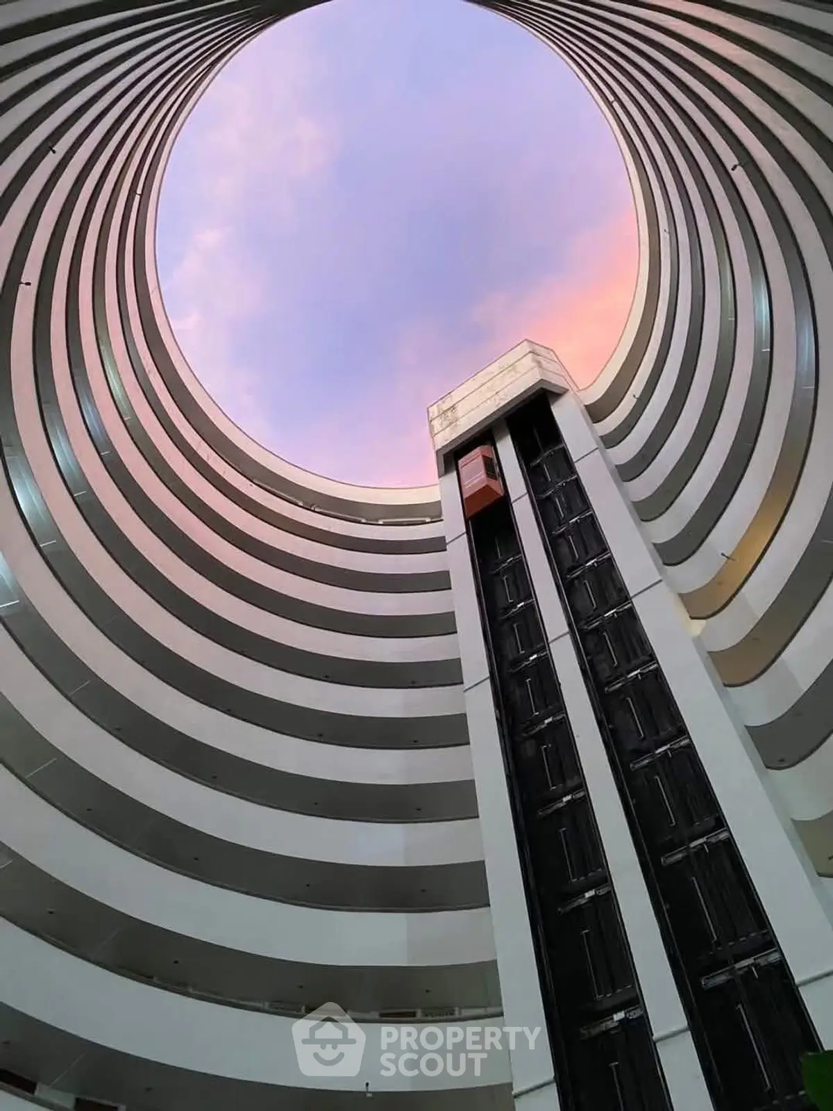 Stunning architectural view of a modern building's circular atrium with elevator