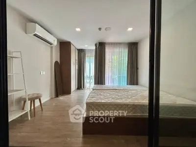 Spacious bedroom with large windows and modern decor, featuring a minimalist design and ample natural light.
