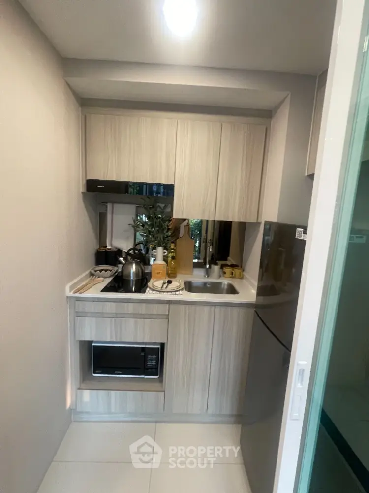 Compact modern kitchen with sleek cabinetry and built-in appliances