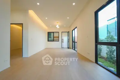 Spacious modern living room with large windows and wooden flooring