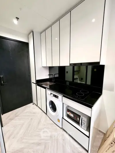 Modern kitchen with sleek cabinets, washing machine, and built-in appliances