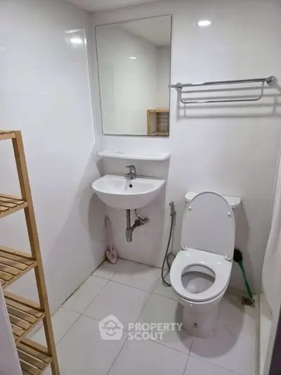 Compact modern bathroom with white fixtures and minimalist design.