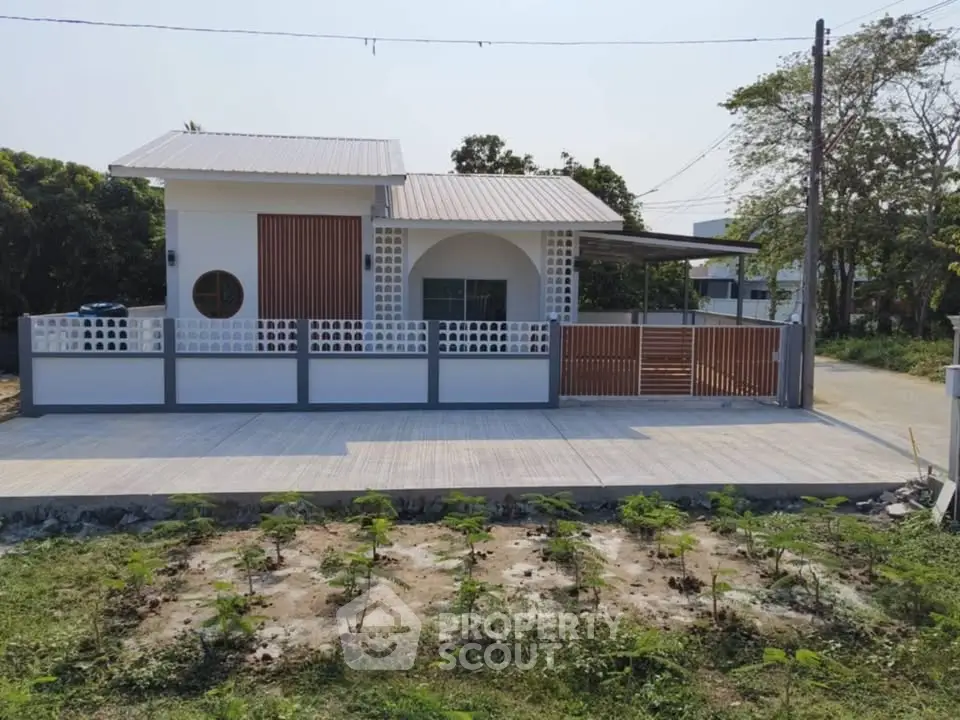 Modern single-story house with spacious driveway and garden area.