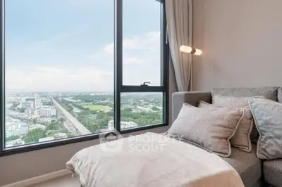 Luxurious living room with panoramic city view from large windows, featuring cozy seating and elegant decor.