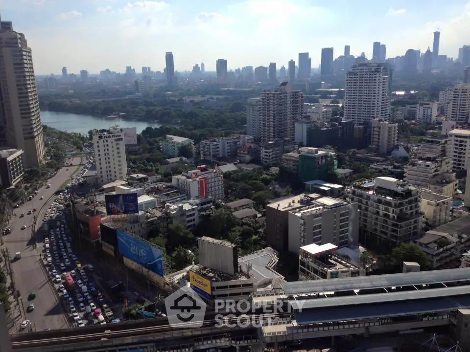 Stunning cityscape view from high-rise building overlooking urban skyline and lush greenery.