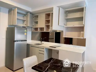 Modern kitchen with sleek cabinetry and marble countertop, featuring stainless steel appliances and ample storage space.