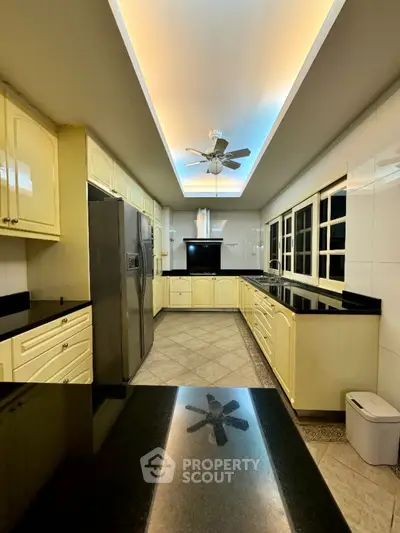 Spacious kitchen with modern appliances and sleek black countertops
