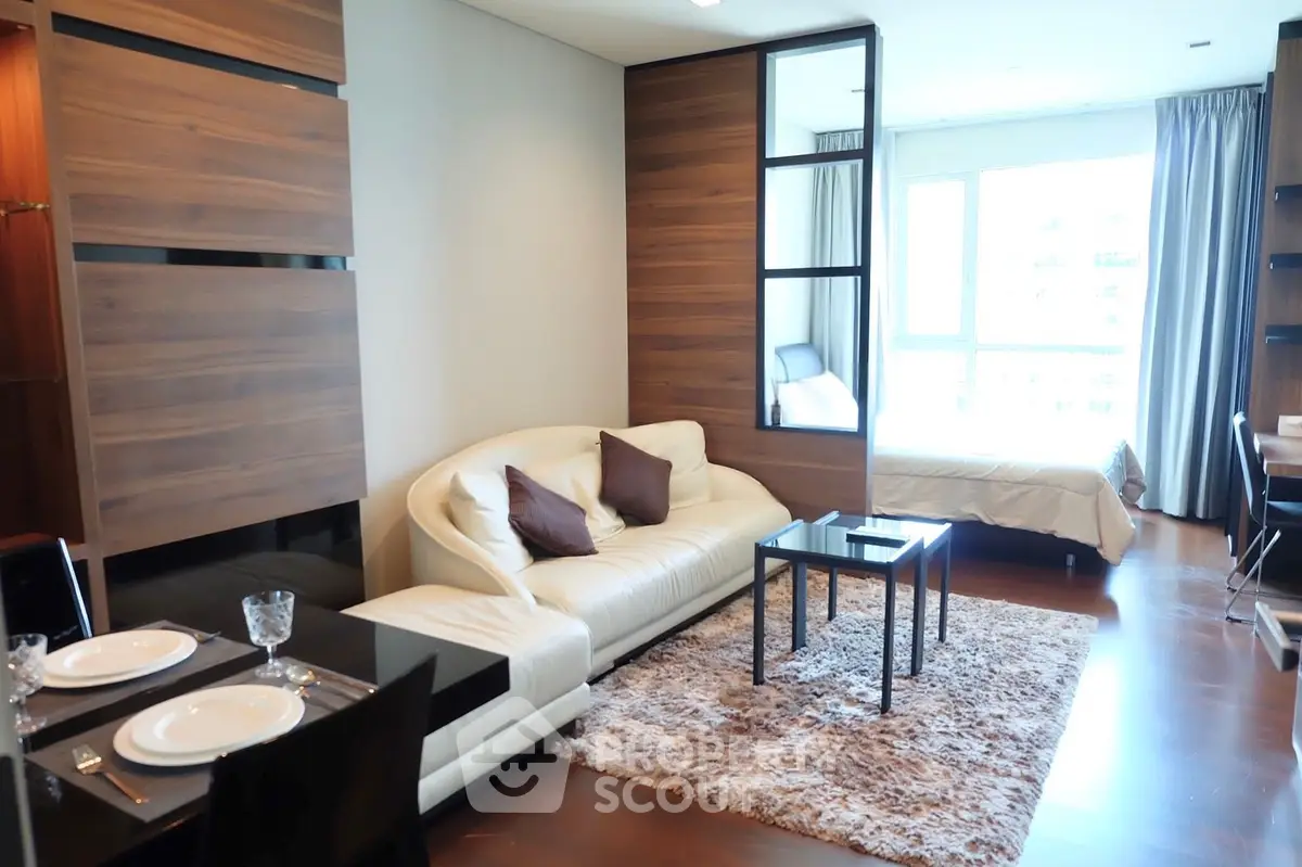 Modern open-plan living room with cozy seating and dining area in a stylish apartment.