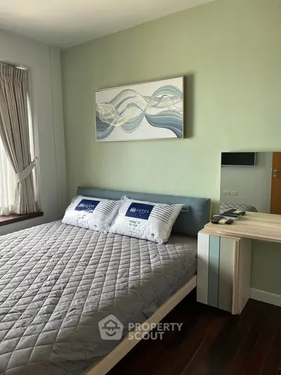 Cozy bedroom with modern decor and stylish bedding in a well-lit apartment.