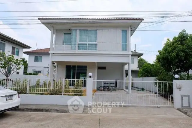 Modern two-story house with spacious driveway and gated entrance in suburban neighborhood.