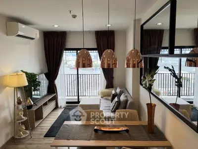 Modern living room with stylish decor and large windows offering natural light and city views.