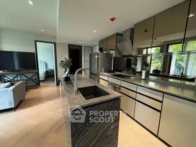 Modern open-layout kitchen with sleek design and spacious living area, featuring stylish countertops and ample natural light.