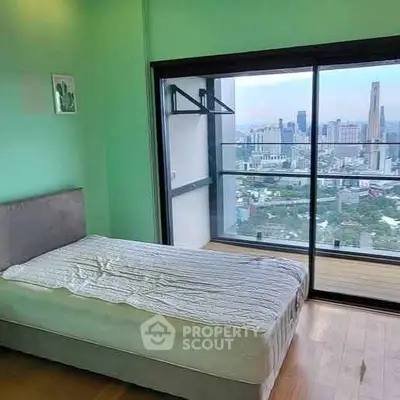 Modern bedroom with stunning city view from large balcony window.