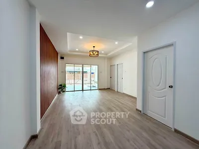 Spacious modern living room with elegant lighting and large sliding doors opening to a patio.