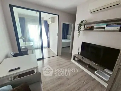 Modern living room with TV, air conditioning, and sliding glass door to bedroom.