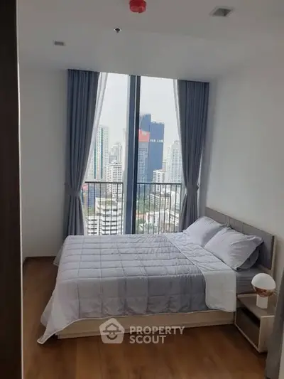 Modern bedroom with city view and large windows in high-rise apartment