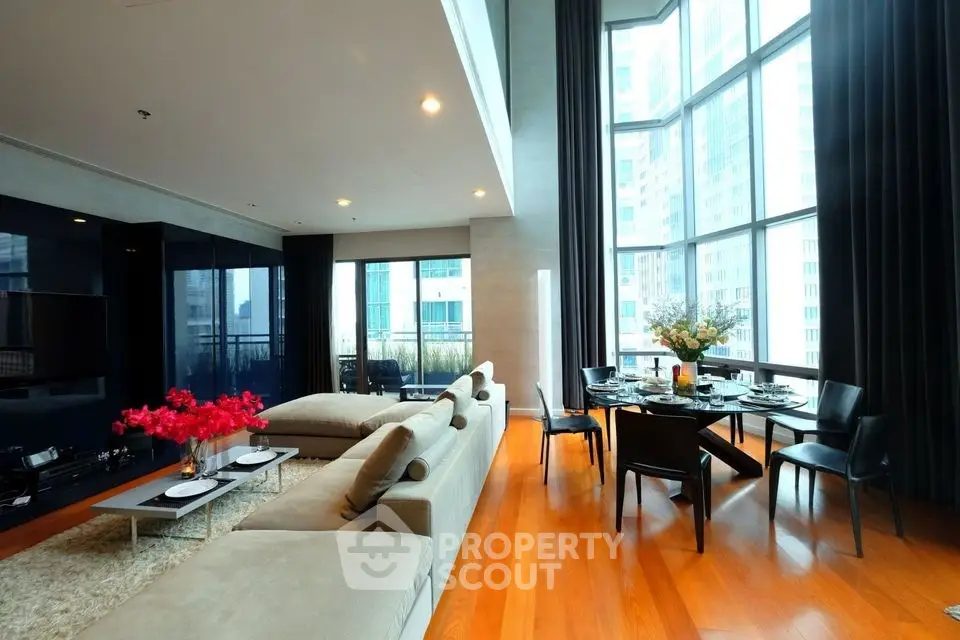 Luxurious modern living room with floor-to-ceiling windows and elegant dining area in high-rise apartment.