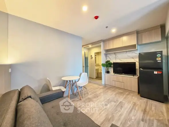 Modern living room with sleek furniture and open layout, featuring a cozy sofa and stylish decor.