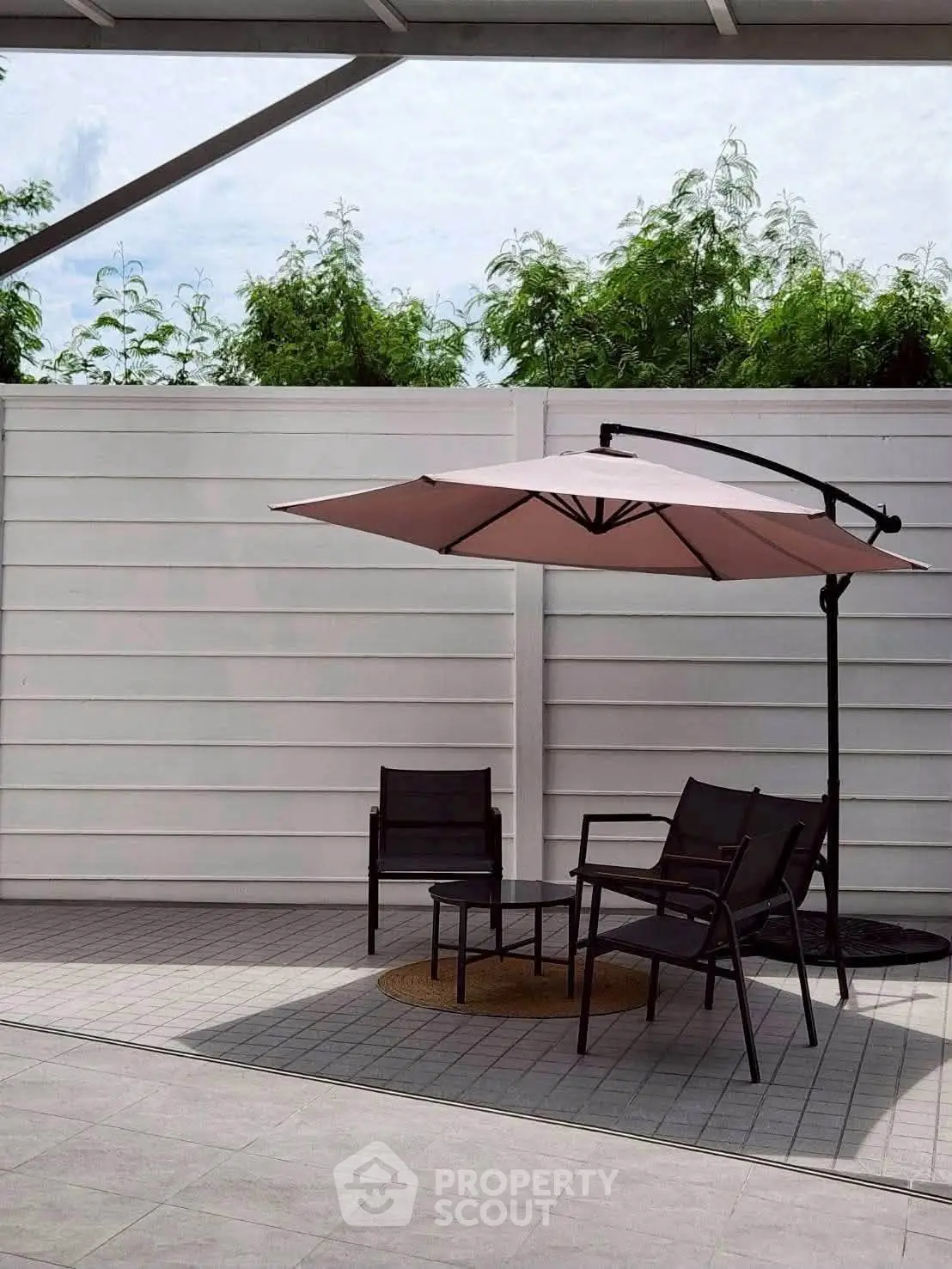 Modern outdoor patio with stylish furniture and umbrella, perfect for relaxation and entertainment.