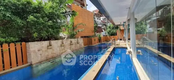Luxurious poolside view with modern architecture and lush greenery, perfect for relaxation and leisure.