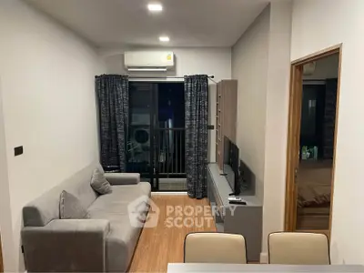 Modern living room with cozy sofa, sleek TV unit, and balcony access in stylish apartment.