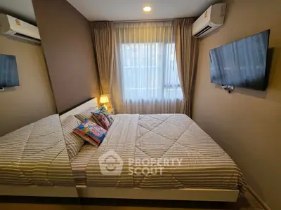 Cozy bedroom with modern decor, featuring a comfortable bed, wall-mounted TV, and air conditioning.