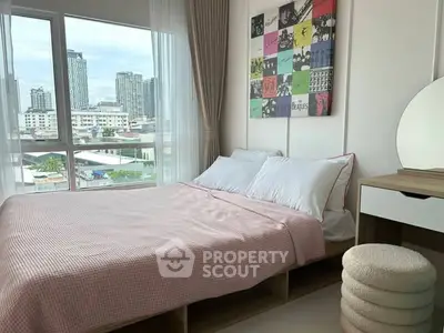 Modern bedroom with city view, stylish decor, and ample natural light.
