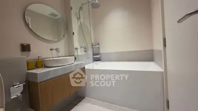 Modern bathroom with sleek design, featuring a bathtub and stylish vanity.
