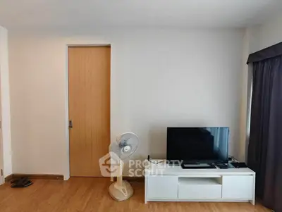 Modern living room with wooden flooring, TV stand, and fan, featuring a minimalist design.