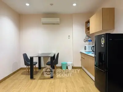 Modern kitchen with sleek black fridge and minimalist dining area