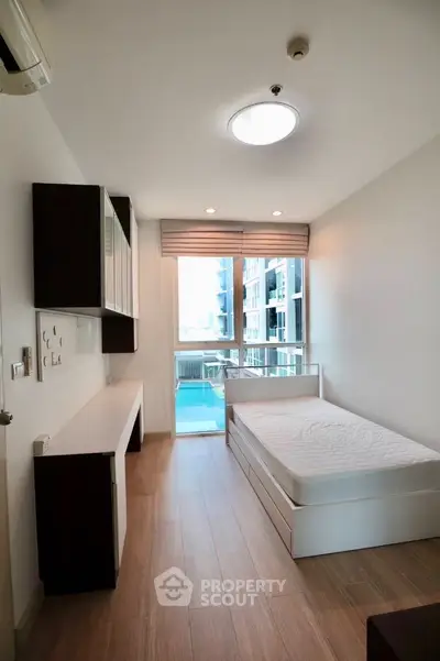 Modern minimalist bedroom with pool view in high-rise apartment