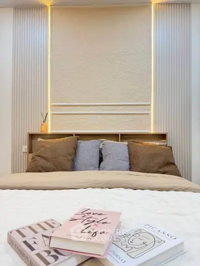 Cozy bedroom with modern lighting and stylish decor, featuring a comfortable bed and elegant wall design.