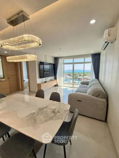 Luxurious modern living room with stunning view, elegant chandelier, and spacious seating area.