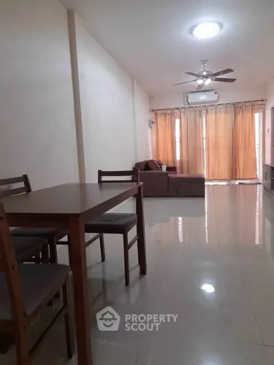 Spacious living room with modern furniture and natural light, perfect for relaxation and entertainment.