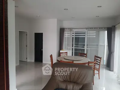 Spacious living room with modern dining area and natural light