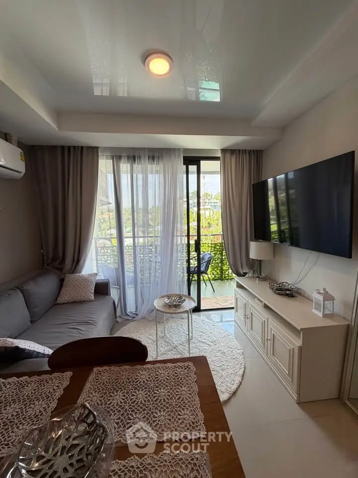 Chic living room with balcony view, modern decor, and cozy seating area.