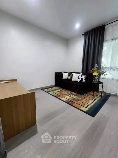 Cozy living room with modern decor and natural light, featuring a stylish sofa and elegant flooring.