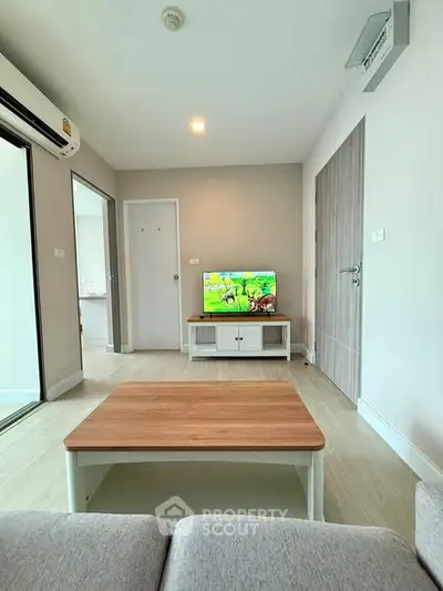 Modern living room with sleek furniture and TV, featuring a cozy ambiance.