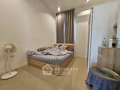 Cozy bedroom with modern furnishings and natural light, featuring a comfortable bed and air conditioning.