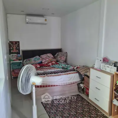 Cozy bedroom with air conditioning and fan, featuring a comfortable bed and ample storage space.