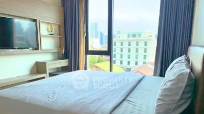 Spacious bedroom with city view and modern furnishings in urban apartment.