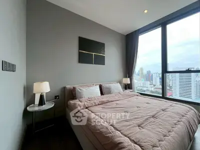 Modern bedroom with large window offering stunning city view, featuring cozy bed and elegant decor.