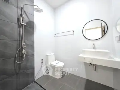 Modern bathroom with sleek shower and stylish round mirror