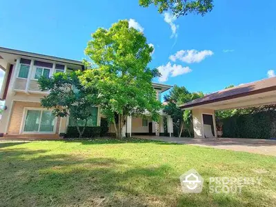 Stunning two-story house with lush green garden and spacious driveway under clear blue sky.