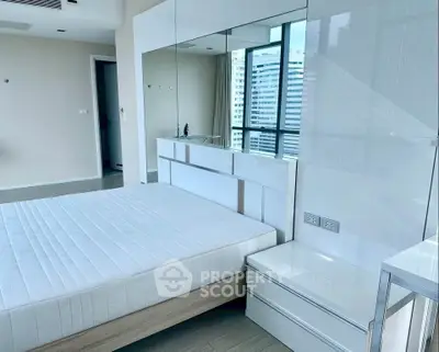 Modern bedroom with large windows and sleek furniture in a high-rise apartment.