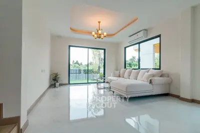 Spacious modern living room with elegant sofa and large windows offering garden view
