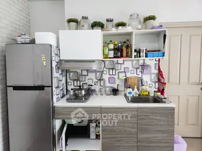 Modern compact kitchen with sleek appliances and stylish backsplash